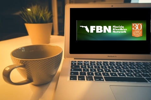FBN logo inside of laptop next to coffee